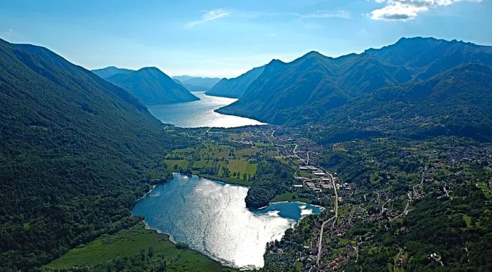 An aerial view of Lake Piano, with Lake Lugano visible in the distance