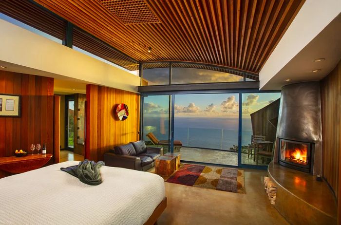 The Cliff House guest room at Post Ranch Inn features a cozy fireplace and floor-to-ceiling windows offering stunning views of the Pacific Ocean.