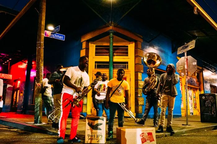 Groups of people playing brass instruments on a street at night