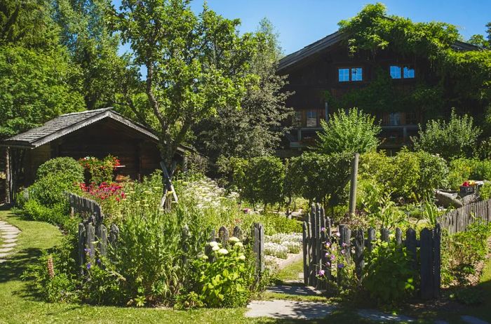 The rustic exterior of Les Fermes de Marie, nestled amidst greenery in Megève, France.