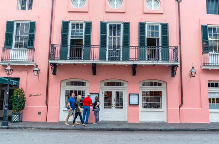 A couple pauses to check the menu at a charming pink restaurant in the French Quarter.