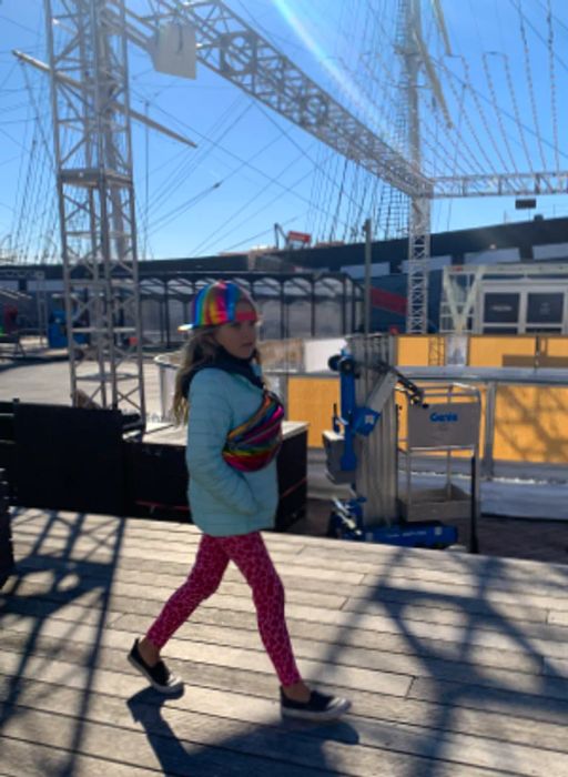 Maya struts through New York City, sporting a holographic cap and a matching bag.