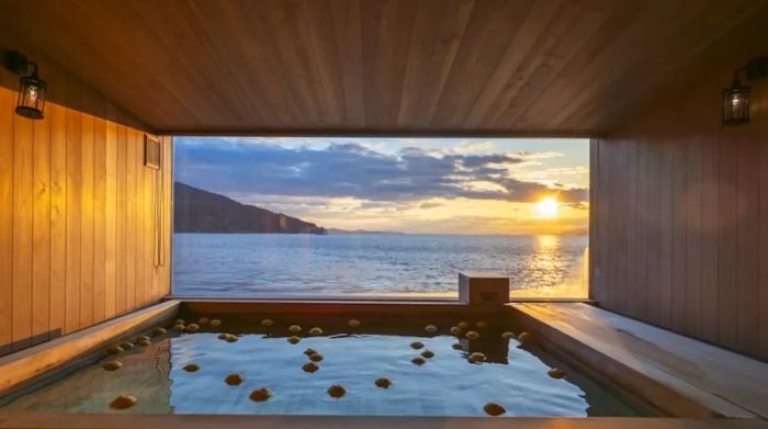 A wooden-paneled communal bath on the Guntû with a view of the ocean