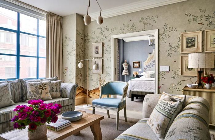 A guest room featuring a more neutral color scheme, adorned with floral wallpaper and striped sofas.