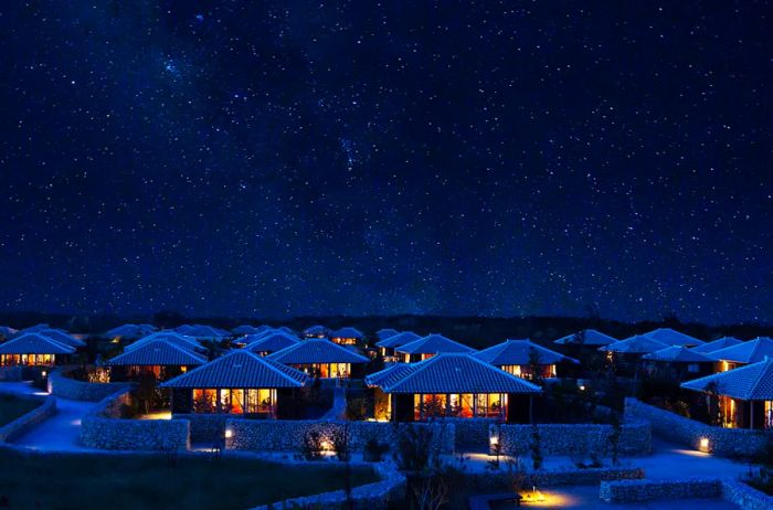 The exterior of the pavilions at Hoshinoya Taketomi Island in Japan during nighttime.