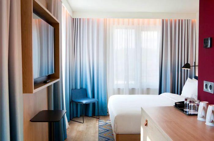 A guest room with drawn curtains at Hampton by Hilton Regensburg, Germany