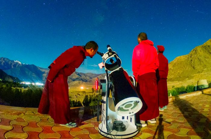 Visitors observing the night sky through a telescope at Astrostays in Ladakh, India, close to Pangong Lake.