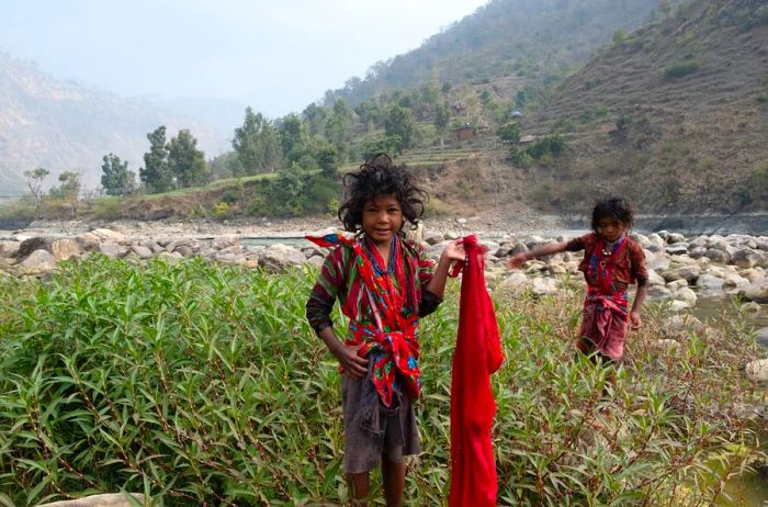 Raute children are seen playing by a river in Nepal.