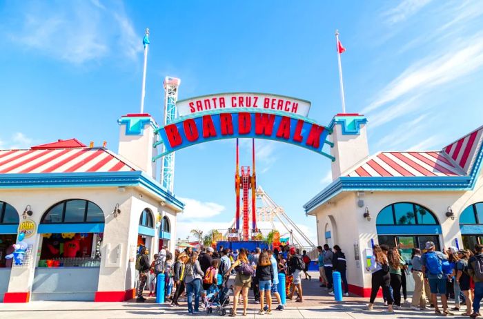 The vibrant red, white, and blue entrance to Santa Cruz Beach Boardwalk, bustling with visitors