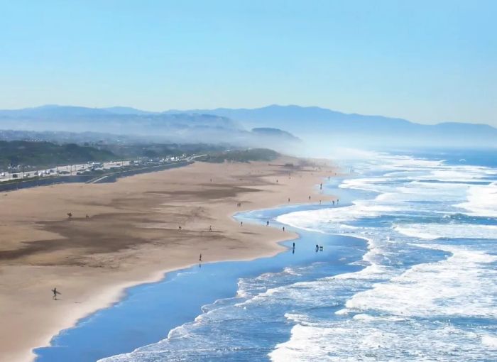 Aerial shot of Ocean Beach with a few visitors scattered along the shore