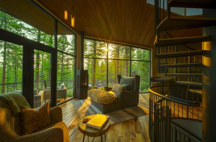 Expansive wall of floor-to-ceiling windows floods the Tree Hause accommodations at the Green O in Montana with natural light.