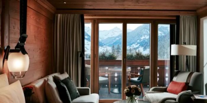 Many guest rooms at the Alpina Gstaad overlook both the charming town and the snow-covered mountains, which are a winter wonderland.