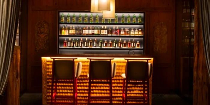 The stylish bar at the Japanese whisky lounge in the Alpina Gstaad showcases wooden shingles and illuminated bottles.