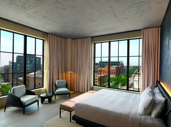 A corner Zen View Suite at the Nobu Hotel Chicago, featuring wooden floors and expansive picture windows showcasing stunning city views.