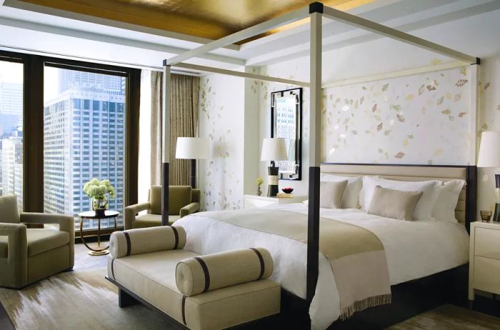 A stylish beige and white Infinity Suite bedroom at the Langham Chicago, featuring tall windows.