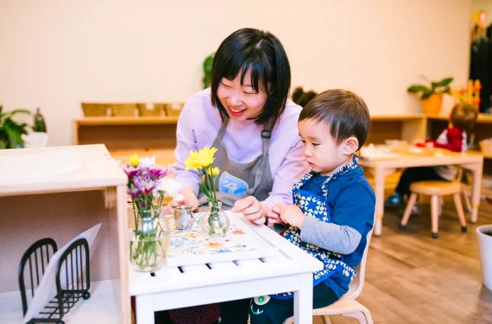 A teacher presenting small flower vases to a young student at a kids club.