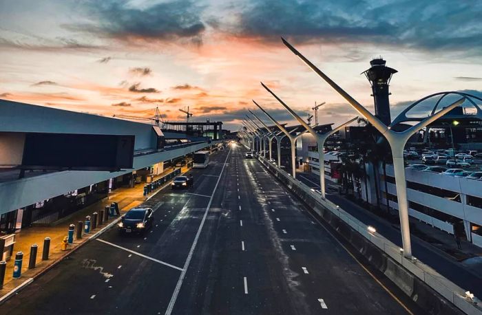 Dusk view of roadways at Los Angeles International Airport (LAX), with terminals on the left and parking structure on the right.