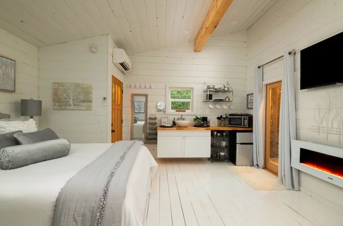 Bright white interior of a North Carolina cabin, featuring a small kitchen in one corner