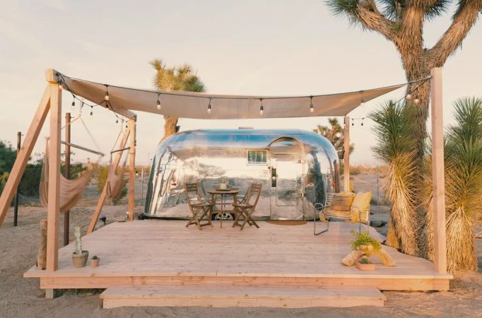 A 1959 Airstream named Kind of Blue, complete with a wooden patio, hammock swings, and Joshua trees