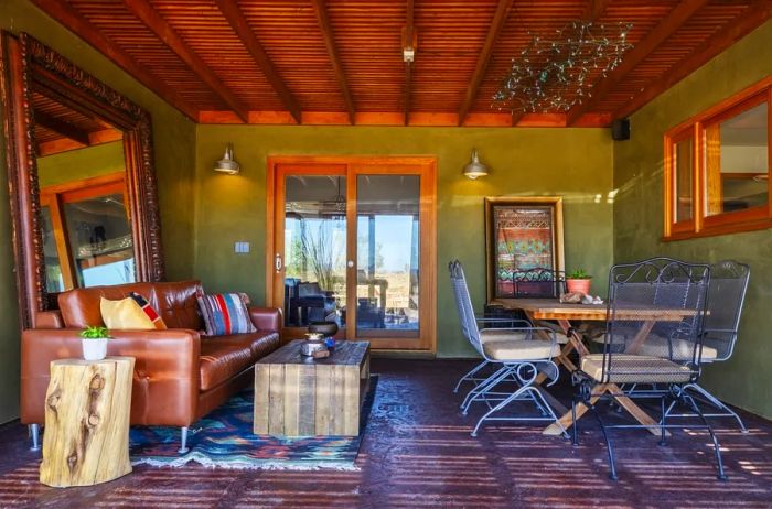 Outdoor lounge area featuring a couch and a dining table