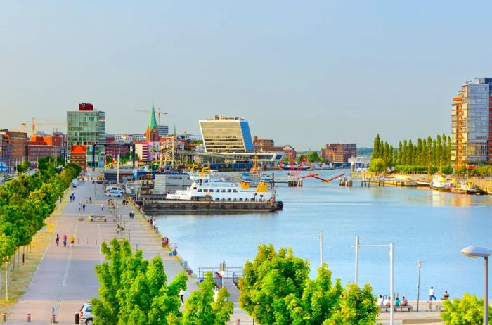 A sweeping view of boats and a riverside walkway along the Port of Kiel, Germany