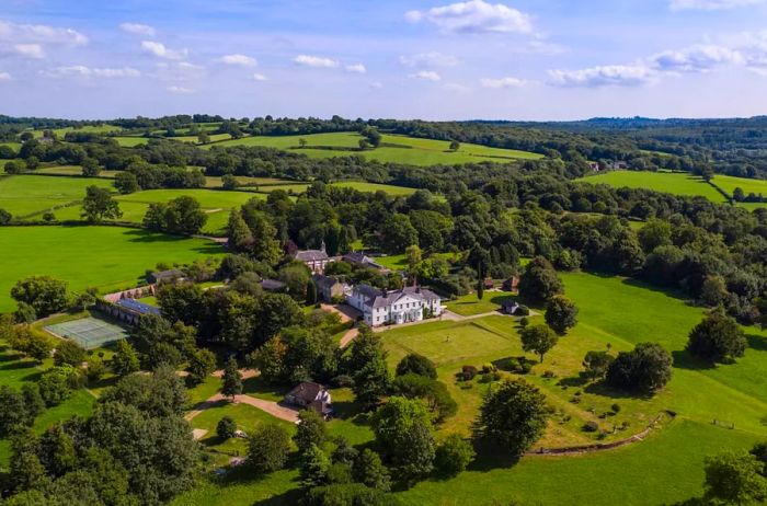 Aerial view of the Georgian manor estate nestled in lush countryside with numerous trees