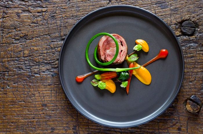 Lamb roulade served with carrot, romanesco, garlic scape, and Swiss chard at Twin Farms in Vermont.