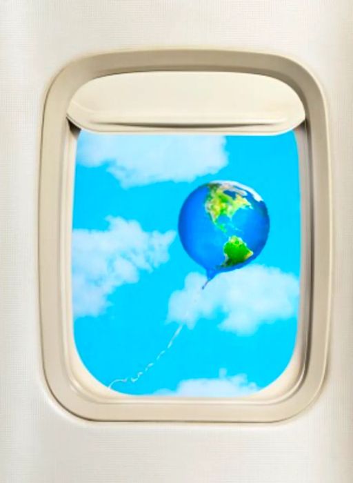 Image of a globe-shaped balloon seen from an airplane window.