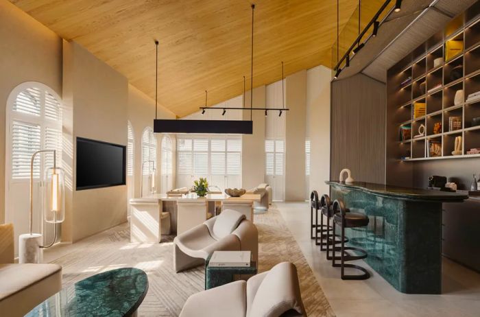 The Shophouse Suite at Mondrian Singapore Duxton features charming wood ceilings, a spacious seating area, and a stylish bar counter.