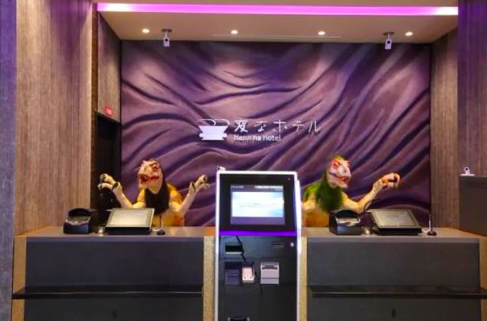 Two robotic dinosaurs in the lobby of a Kyoto hotel, set against a purple backdrop.