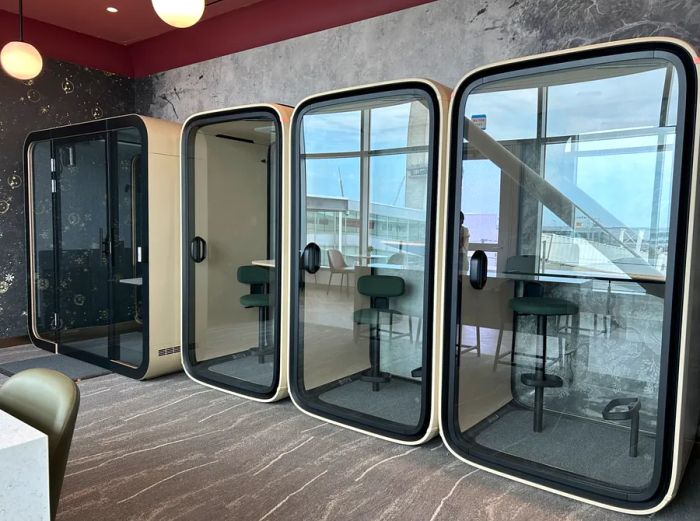 A row of four soundproof booths at the Delta Sky Club Lounge, JFK, Terminal 4, Concourse A.