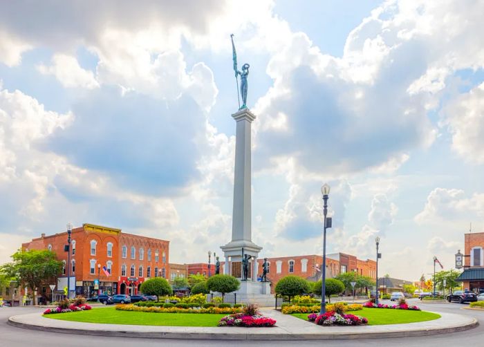 The imposing Steuben County Soldiers Monument stands in a roundabout in downtown Angola, framed by charming red-brick buildings.
