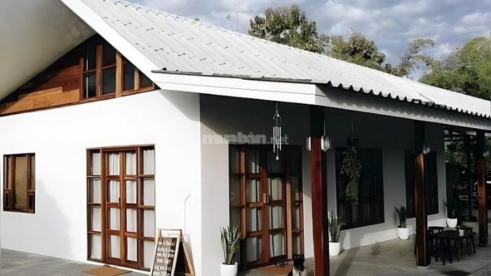 Ngôi nhà mái tôn xanh với thiết kế đơn giản và mặt tiền rộng rãi, thoáng đãng