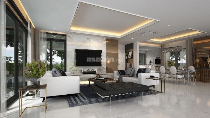 Phòng khách biệt thự được trang trí với tông màu trắng và vàng, tạo nên vẻ sang trọng và đẳng cấp.