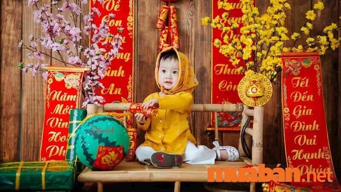 Chụp ảnh Tết cho bé trai bên mâm cỗ Tết đầy ắp món ngon