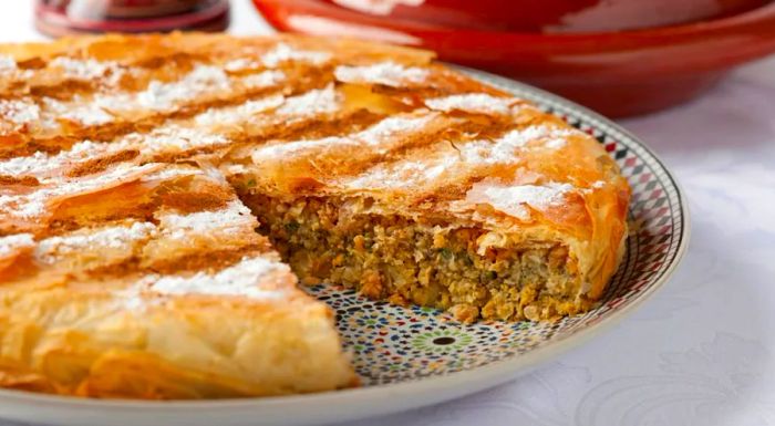 Moroccan Pastilla is a flavorful dish that typically combines aromatic spices, poultry, eggs, and almonds.