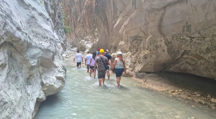 Safety helmets are recommended in the narrow canyon, where loose rocks can tumble down from the steep cliffs.