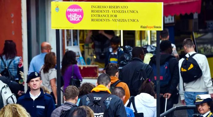 On the May Day weekend, citizens and tourists in Venice navigate turnstiles designed to control the influx of visitors and limit overcrowding.