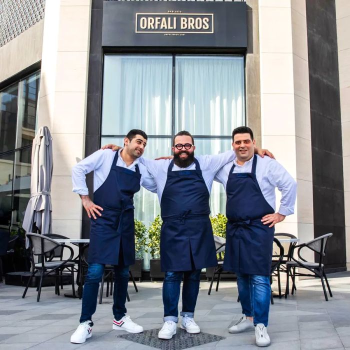 The Orfali brothers standing outside their restaurant.