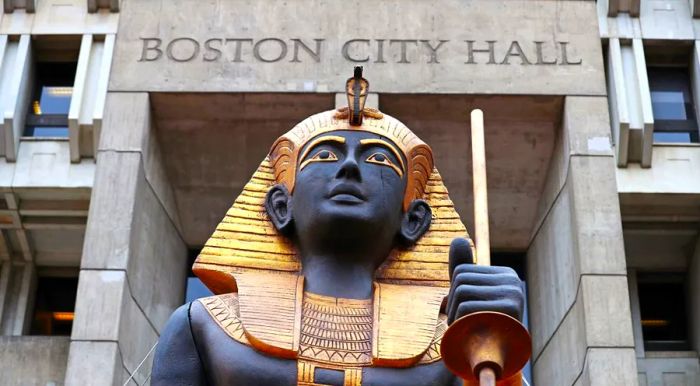 A massive gold and black statue of an Egyptian tomb guardian has been placed in Boston's City Hall Plaza to promote the immersive exhibit set to open this June.