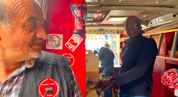 Patrice Clouzeau, left, and Jean-Michel Arcarde, both refuse workers from France's CGT labor union, are hard at work in a sausage vending truck.