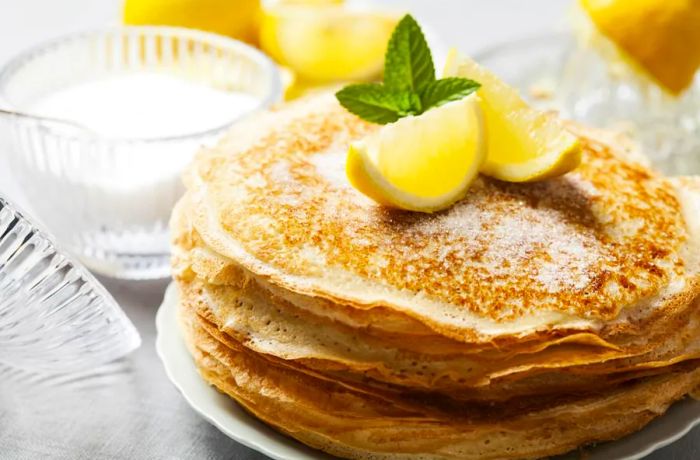 Classic English pancakes are typically topped with a sprinkle of sugar and a squeeze of fresh lemon juice.