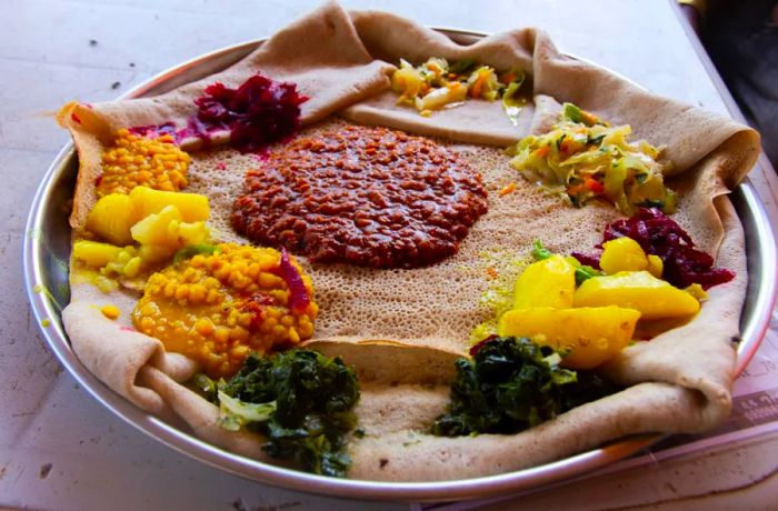 Injera is a large, tangy flatbread made from teff flour, often used as a base for Ethiopian cuisine.