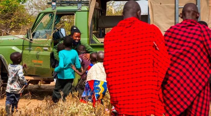 Children eagerly rush to greet Purity Amleset Lakara, a member of the all-female IFAW-supported Team Lioness, as she returns to her home village in Meshenani, Amboseli, Kenya.