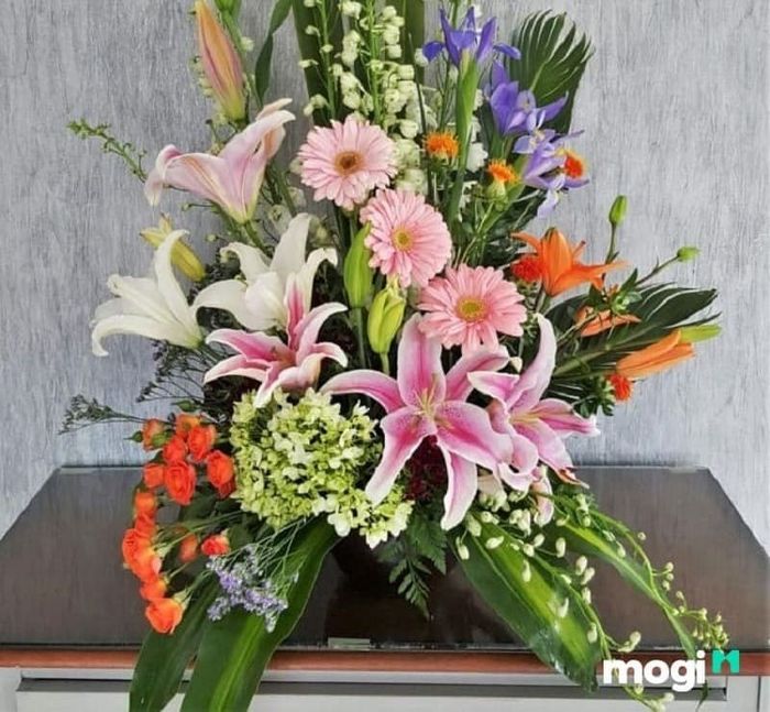 Cắm hoa ly kết hợp với các loài hoa khác như hoa đồng tiền, hoa hồng tạo nên một lẵng hoa hài hòa và ấn tượng.