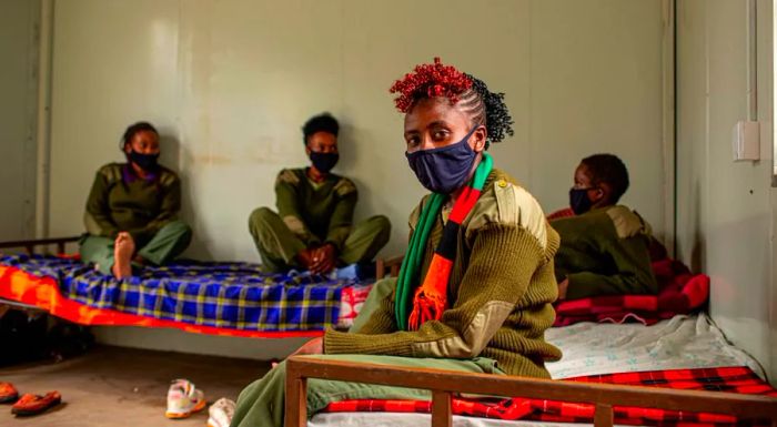 Community ranger Eunice Mantei Nkapaiya relaxes with her colleagues at their camp. The women spent months away from their families as they worked in the bush.