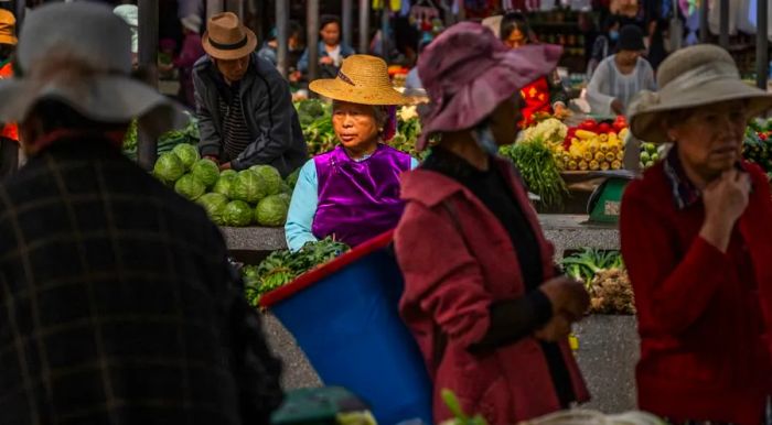 Bai women selling goods at a bustling market in Xizhou, Yunnan province.