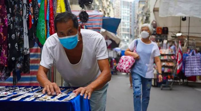 Mr. Chan stands at his stall in the Hong Kong Ladies' Market.