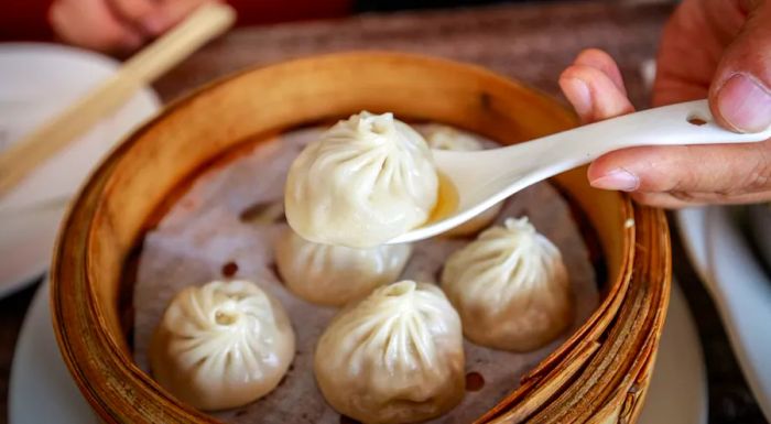 When eating a xiaolongbao, be sure to use a spoon to catch the soup that spills out from the delicate dumpling.