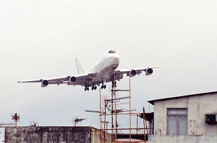 Not something you’d typically see at most airports – a plane soaring just above bamboo scaffolding and TV antennas.